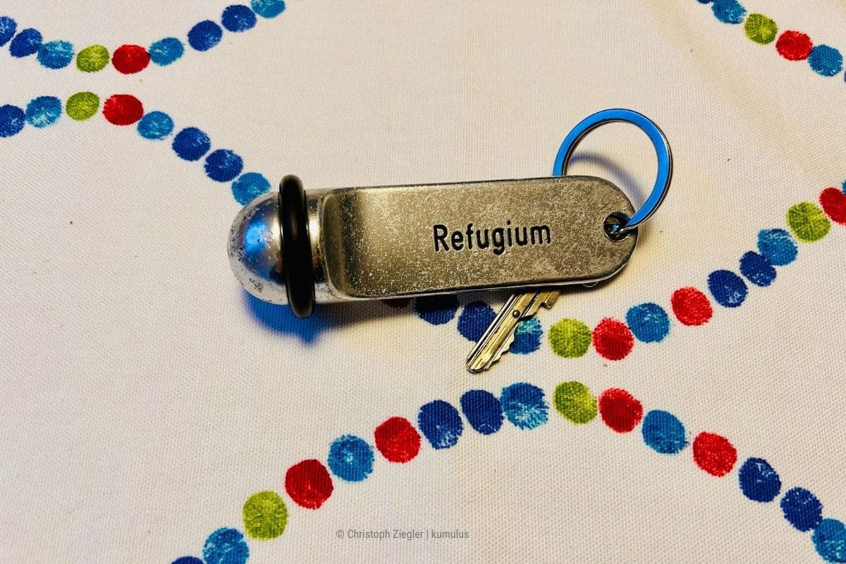 Das Bild zeigt einen Schlüssel mit der Aufschrift "Refugium" – als Metapher für einen Ort, an dem Du Selbstvertrauen aufbaust (Photocredit: eigenes Material von Christoph Ziegler, kumulus Social Media Beratung).