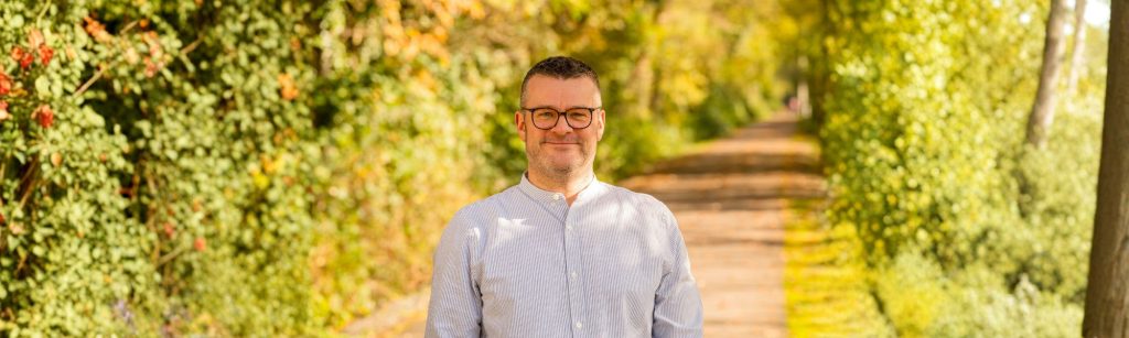 Das Bild zeigt Christoph Ziegler (Moderator, Digital Stratege, Systemischer Coach) in einer herbstlichen Landschaft (Photo: Daniel Schmitt, Spitzlicht Fotografie Wuppertal, KI-bearbeitet).